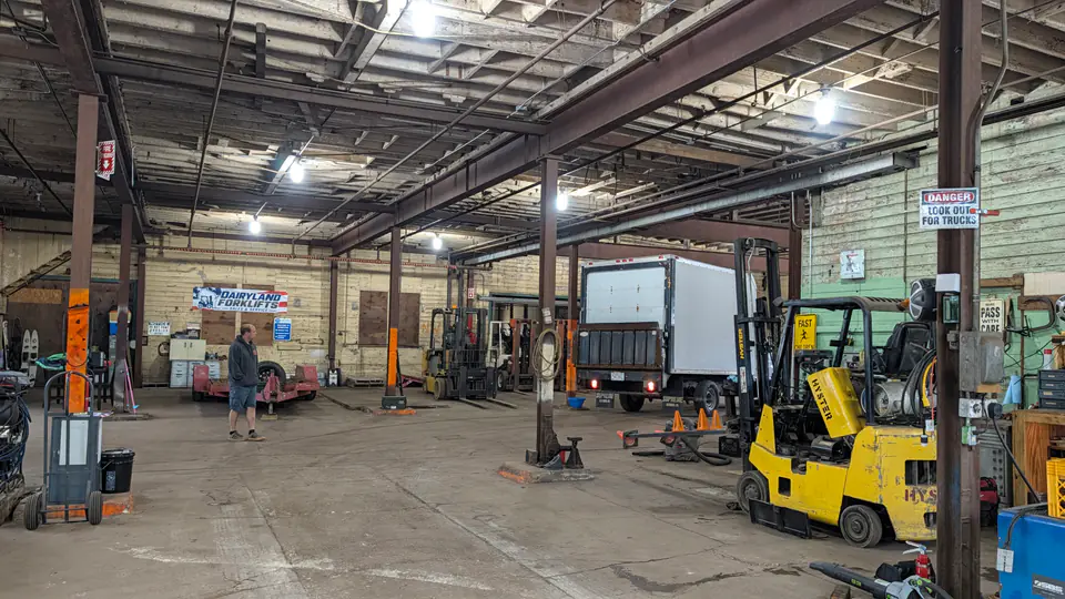 Wide view of the Dairyland workshop with forklifts, workbenches, and a truck